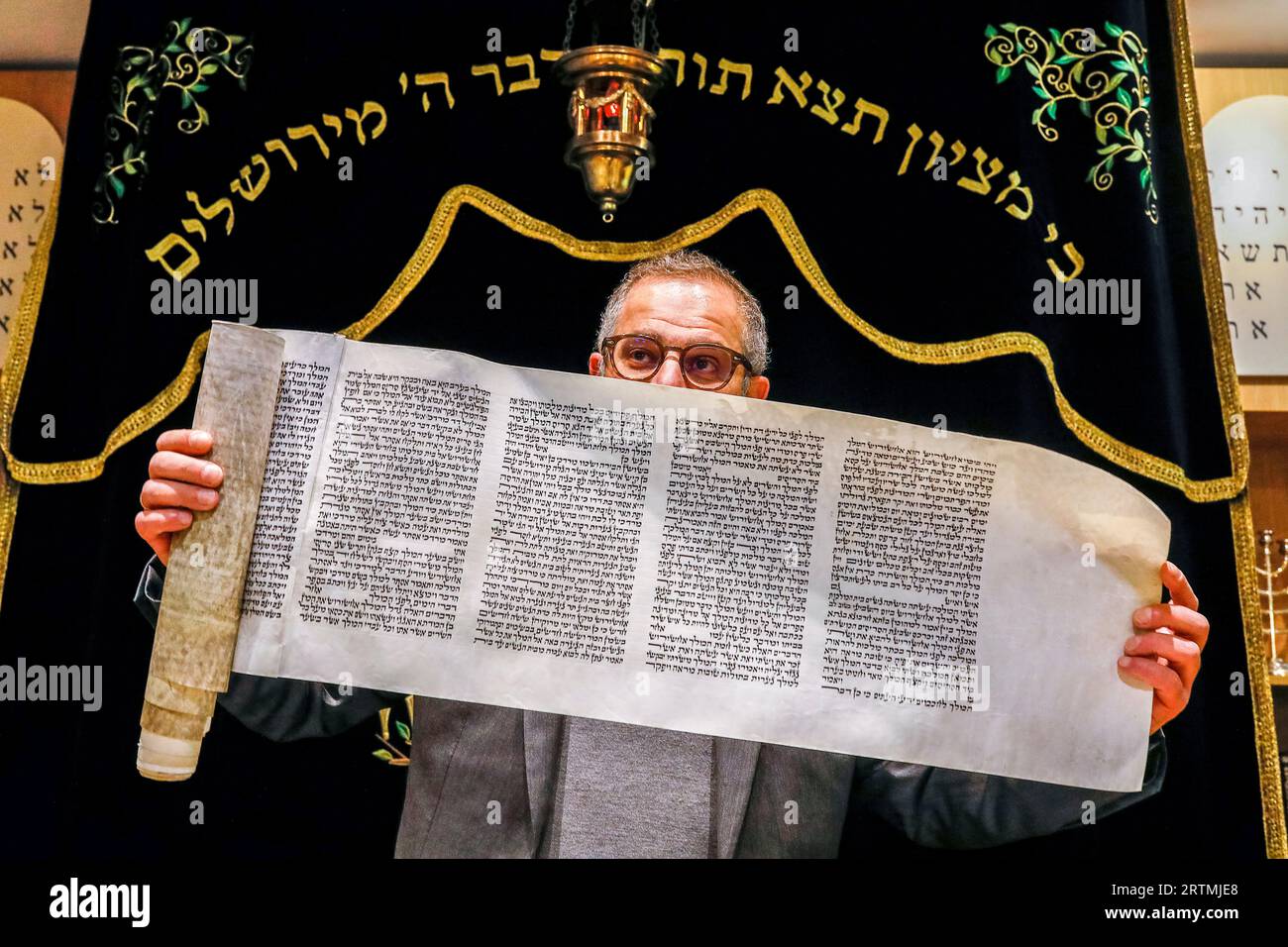 Purim celebration in Beth Yaacov synagogue, Paris, France. Rabbi Gabriel Farhi showing the scroll of the book of Esther Stock Photo