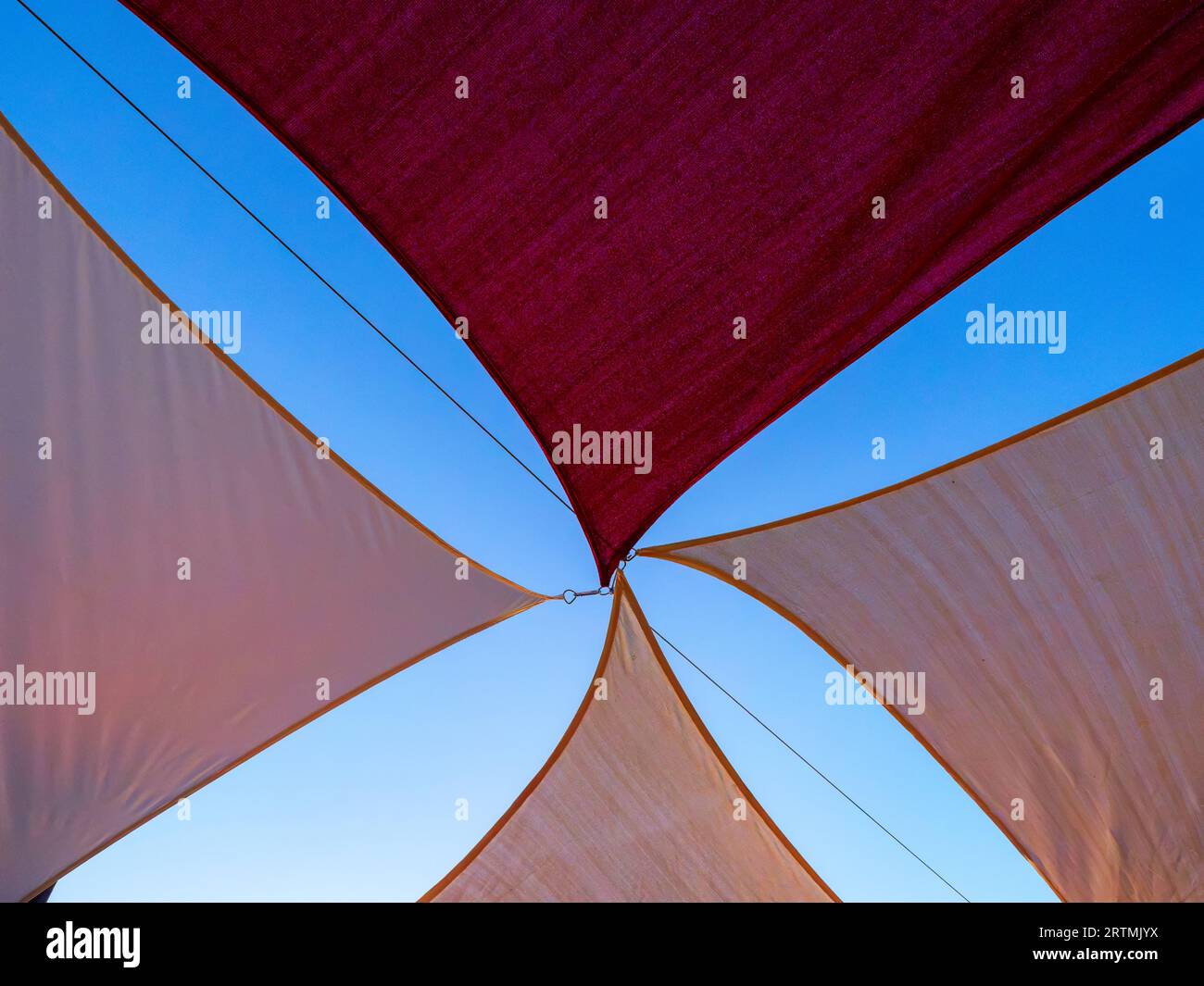 Coloured awnings hung with ropes Stock Photo