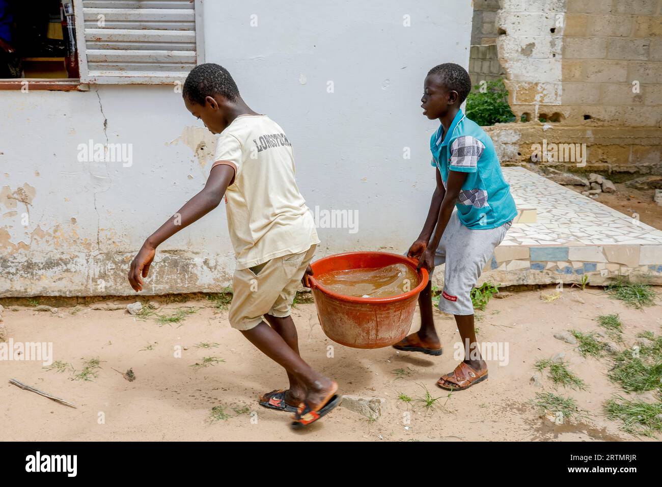 Boys fetching water in Thiaoune, Senegal Stock Photo