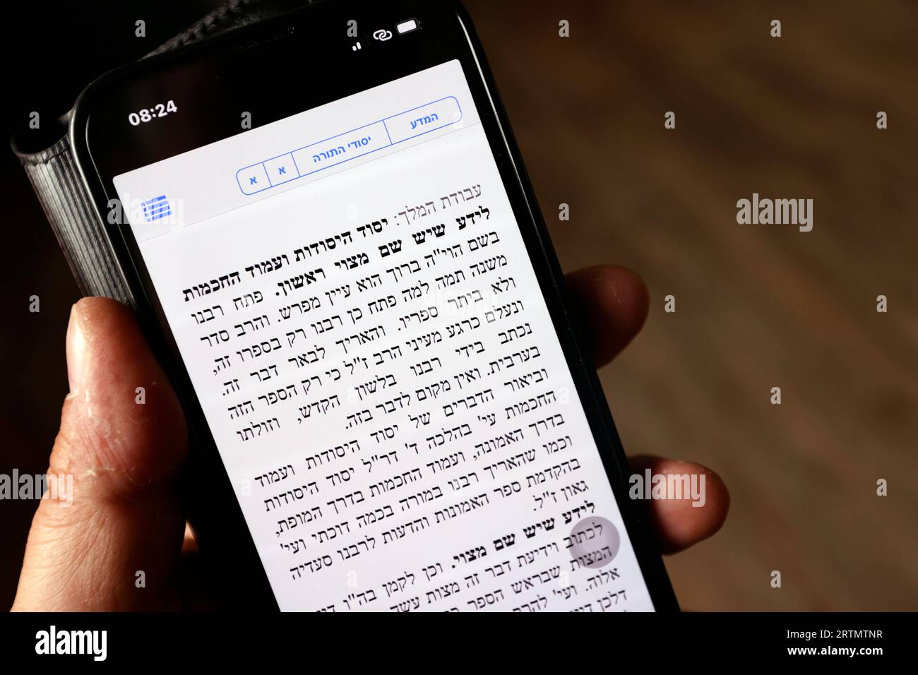 Digital Torah app on a smartphone. Man reading the Torah in hebrew. Stock Photo