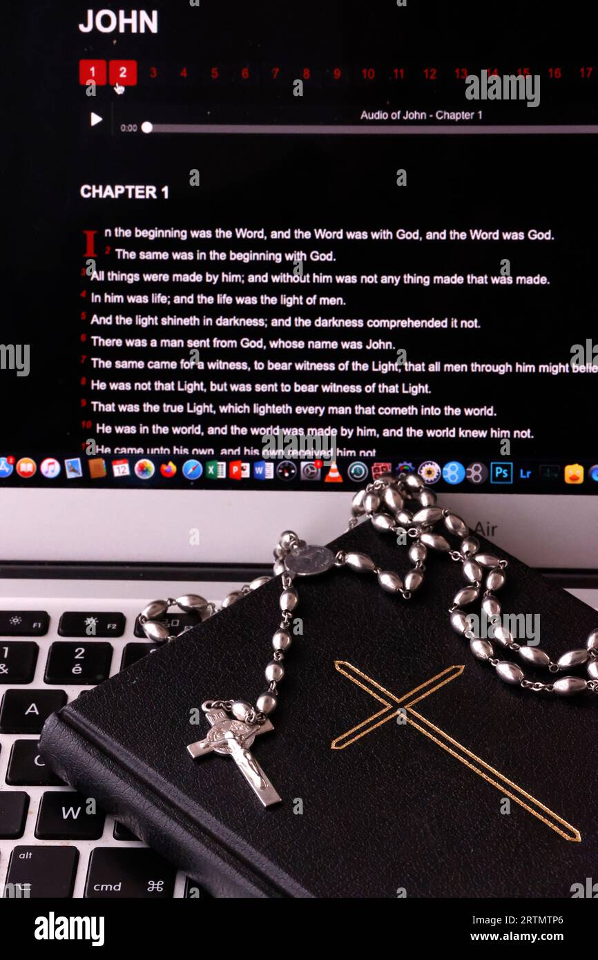 Rosary, paper Bible and digital Bible app on a  laptop.  Christian religious symbols. Stock Photo