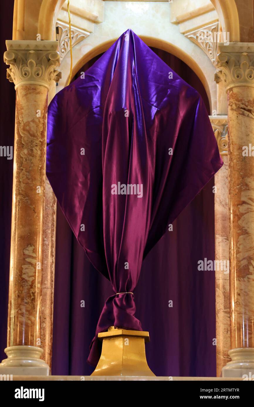 Catholic church. Lent and Holy Week. Sacred image covered with purple fabric. Religious symbol