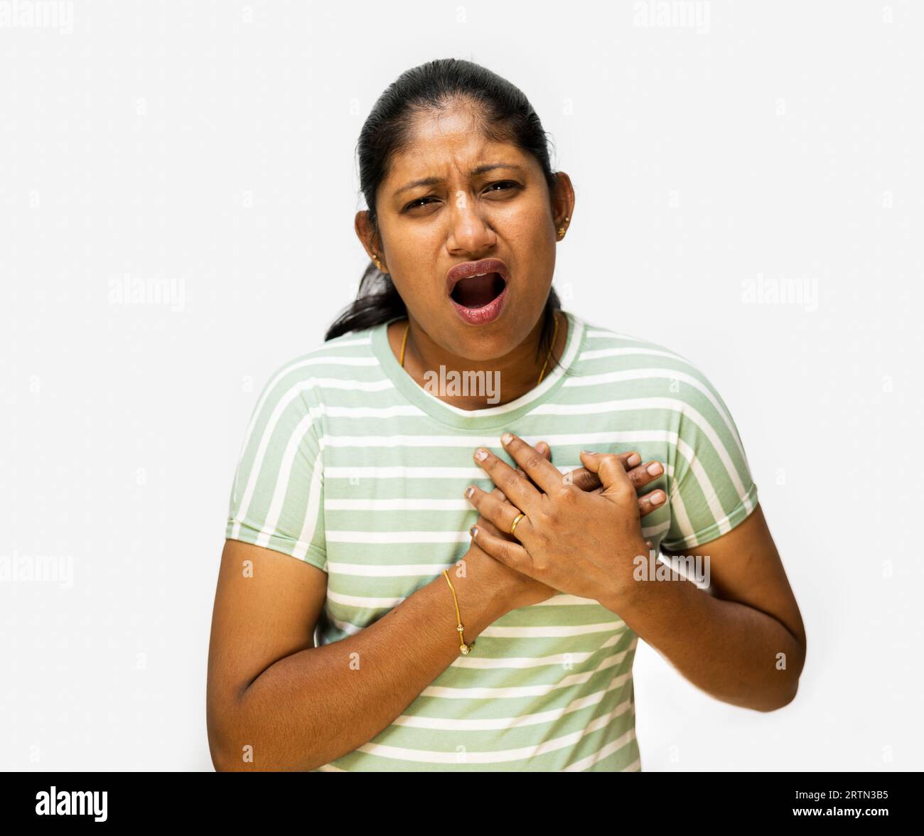 A woman is clutching her chest in pain. She may be having a heart