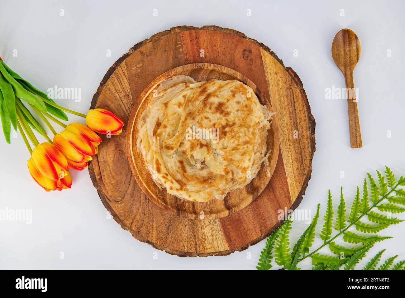 Malabar parota in an isolated background. South Indian Porata in a wooden plate and decorated and isolated. Also called nool porata, Roti Parata or Ro Stock Photo