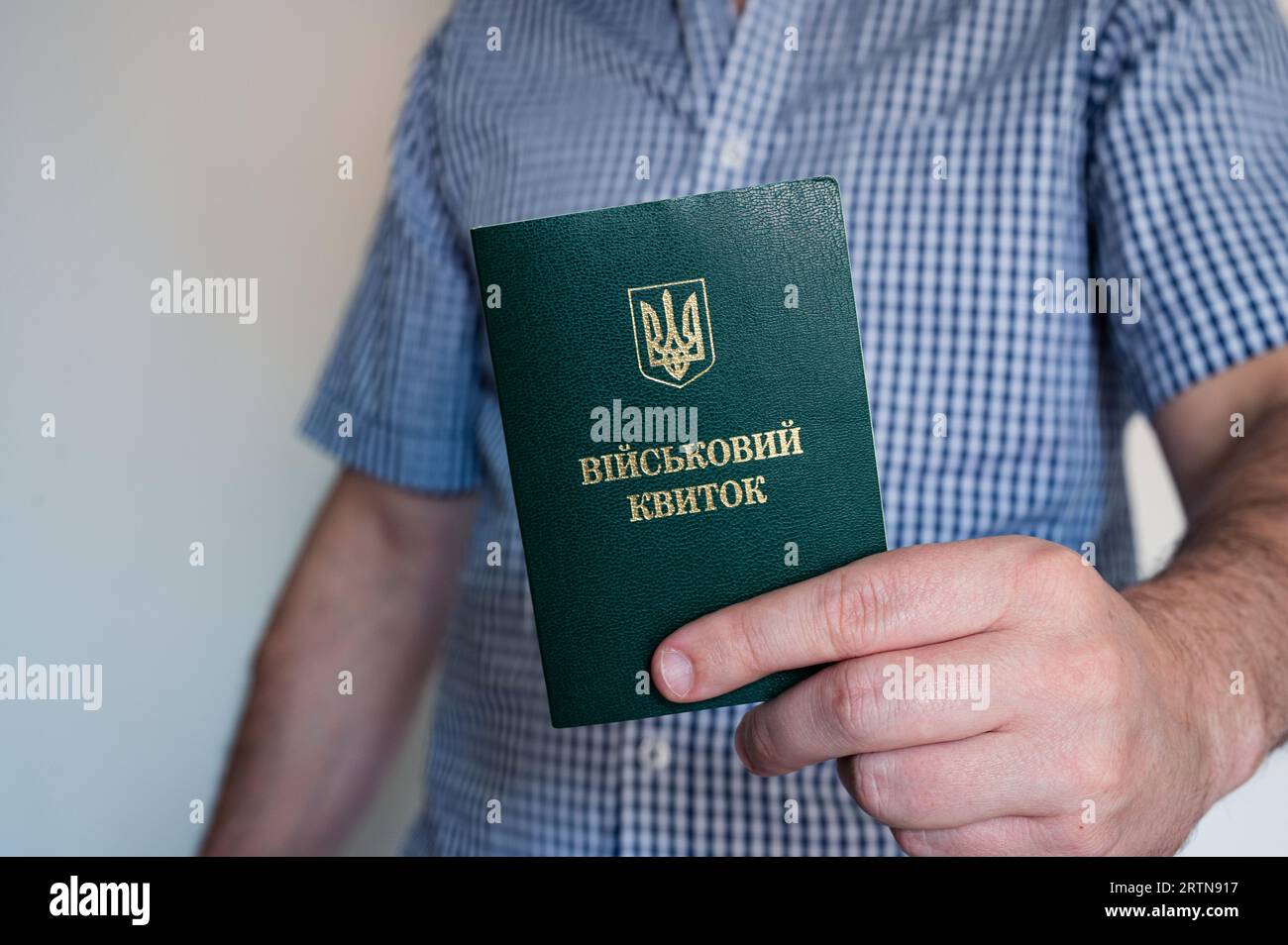 Translation: 'military id'. Civil man in shirt with army document for rookie, veteran, soldier in hand on white background Stock Photo