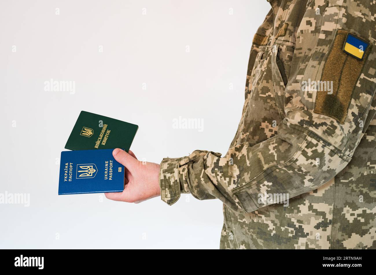 Translation: 'military id'. Soldier in ukrainian pixel uniform holding passport and military doc. Border officer Stock Photo