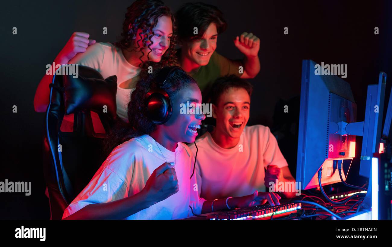 Group of multiracial teens playing video games in video game club with