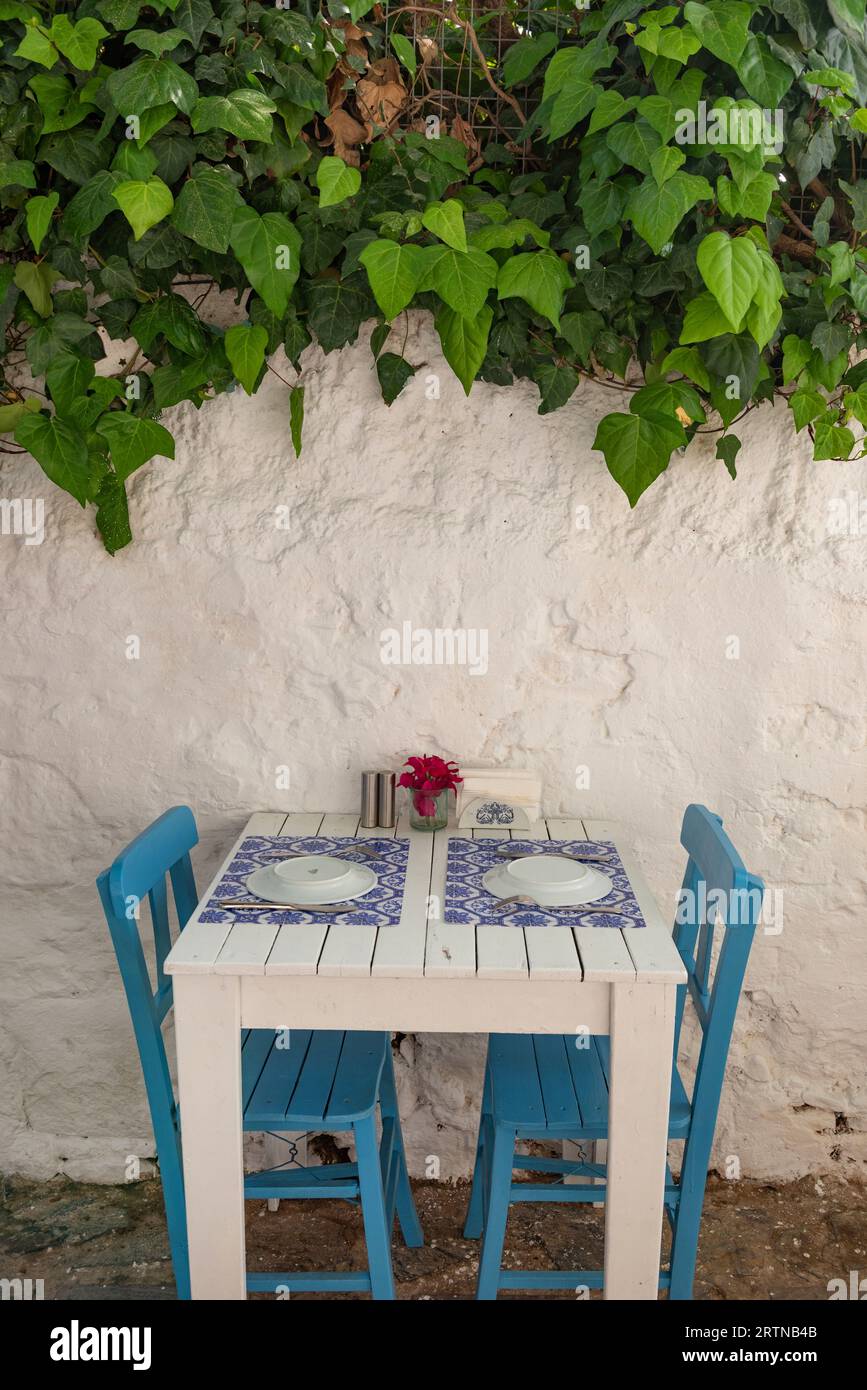 Pretty blue and white cafe restaurant table in a shaded side street in the popular tourist