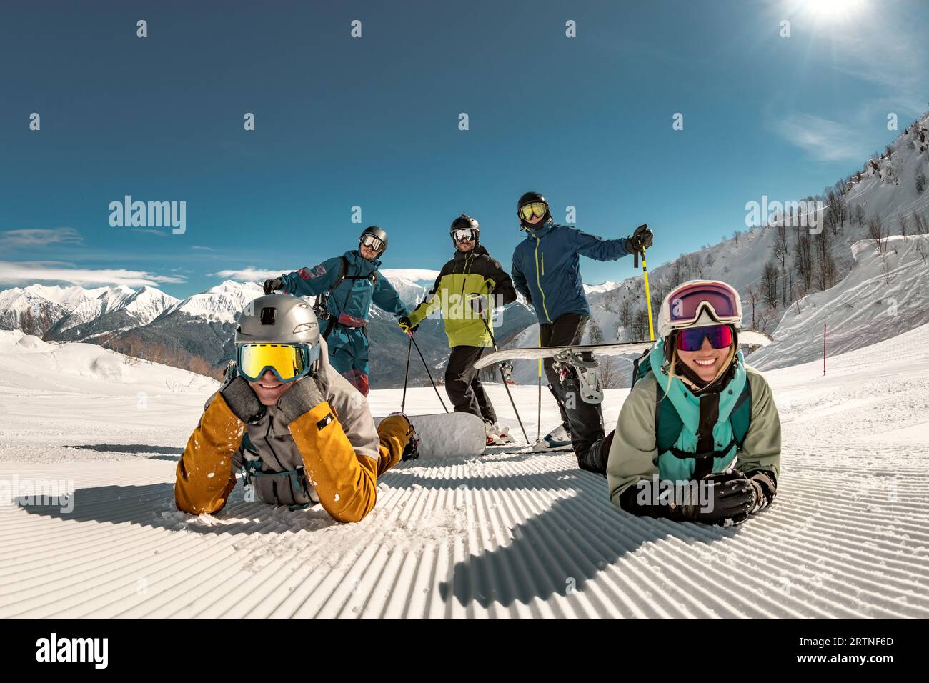 Group of happy young friends skiers and snowboarders are having fun and posing for photo at ski resort. Winter holidays concept Stock Photo