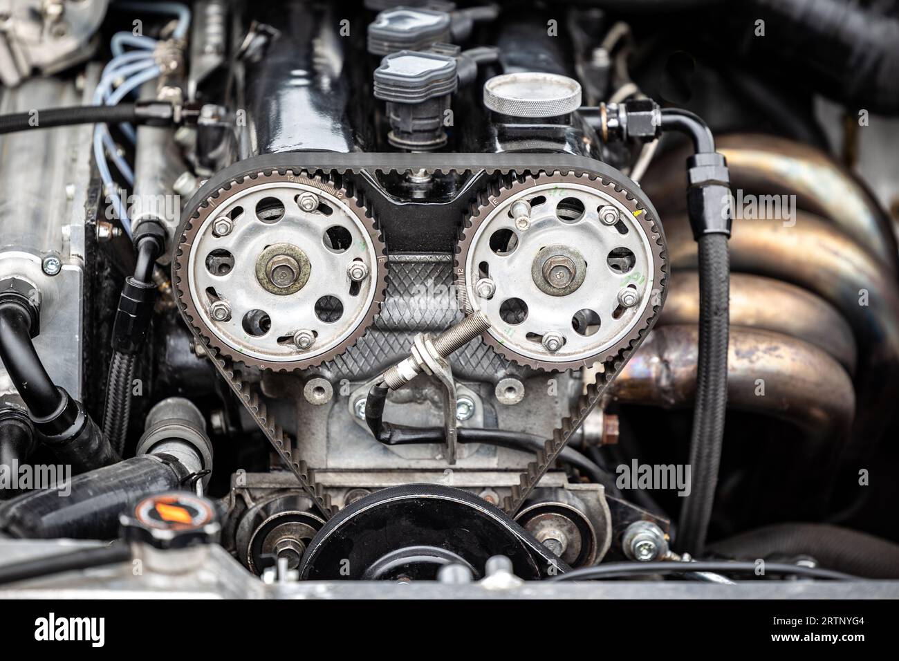 Twin cam engine car with pulley wheels and cam belt in view of engine bay. Stock Photo