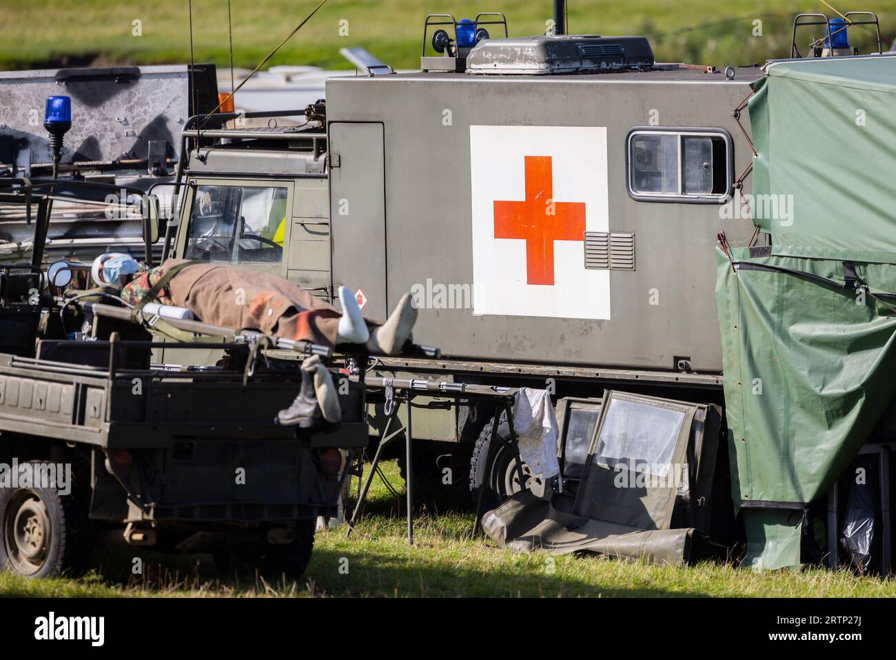 Military soviet era first aid base red cross with army vehicles combat medics and stretcher Stock Photo