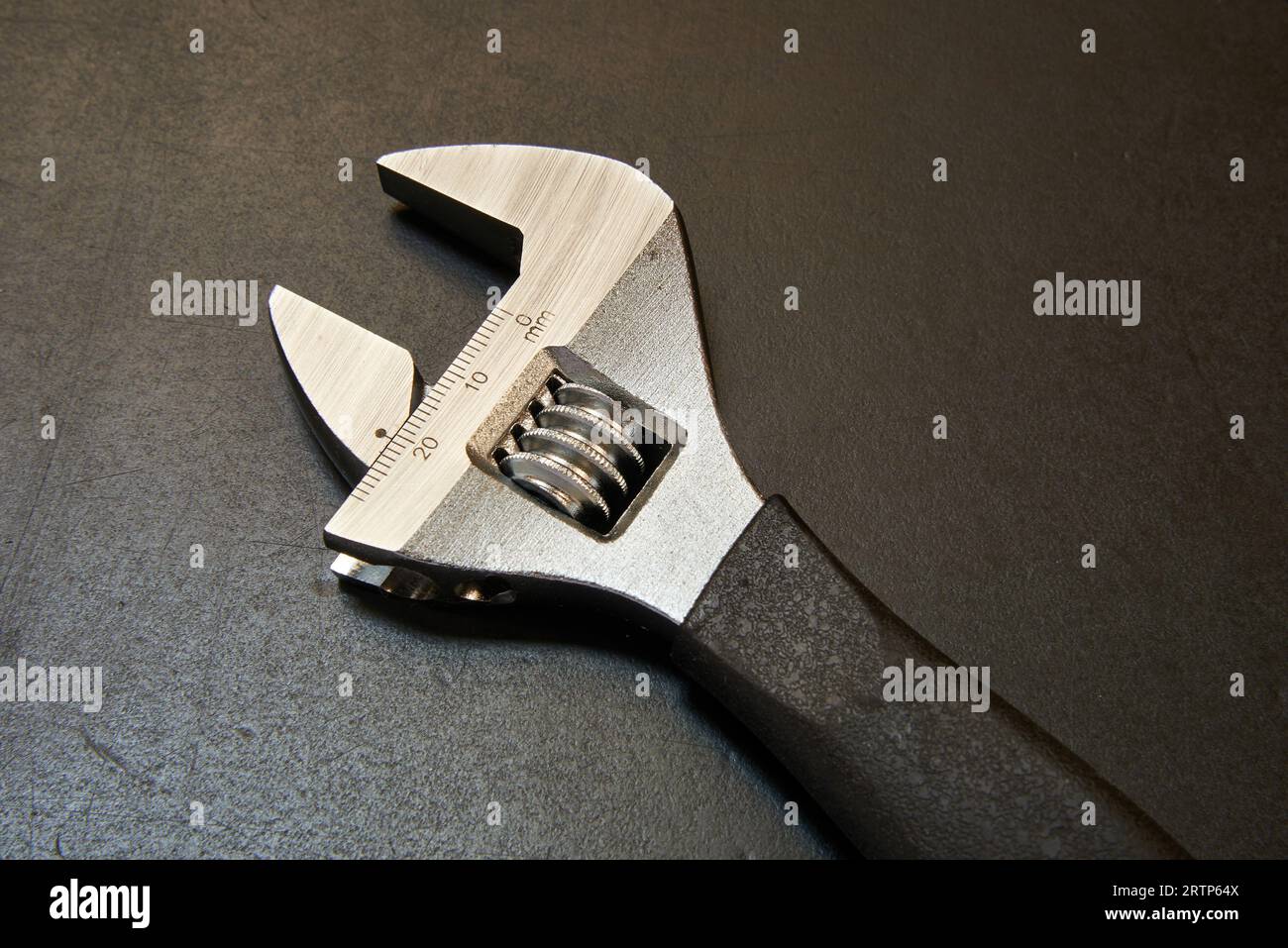Adjustable wrench with measuring tool on black wooden table Stock Photo