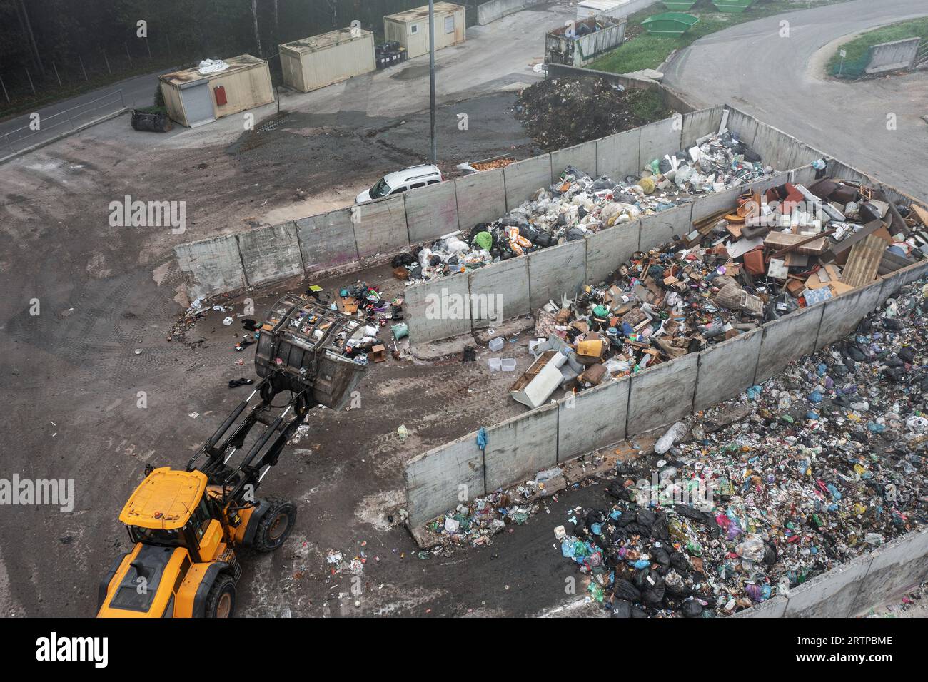 Wheeled loader loading bucket with garbage material and moving it