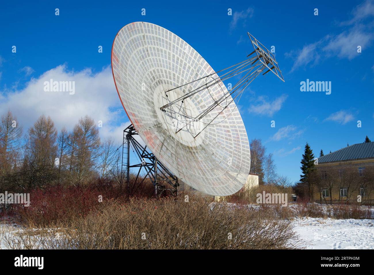 The antenna of the radio telescope at the building of the astrophysical laboratory on a sunny February day. Pulkovo Astronomical Observatory, Saint Pe Stock Photo