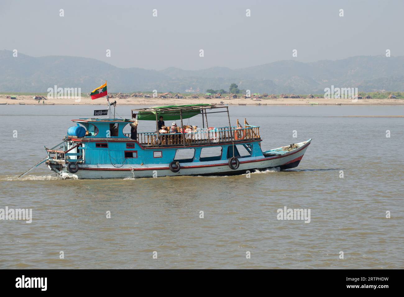 MANDALAI, MYANMA - DECEMBER 21, 2016: Boat with European tourists on a river walk along the Irrawaddy River. Burma Stock Photo