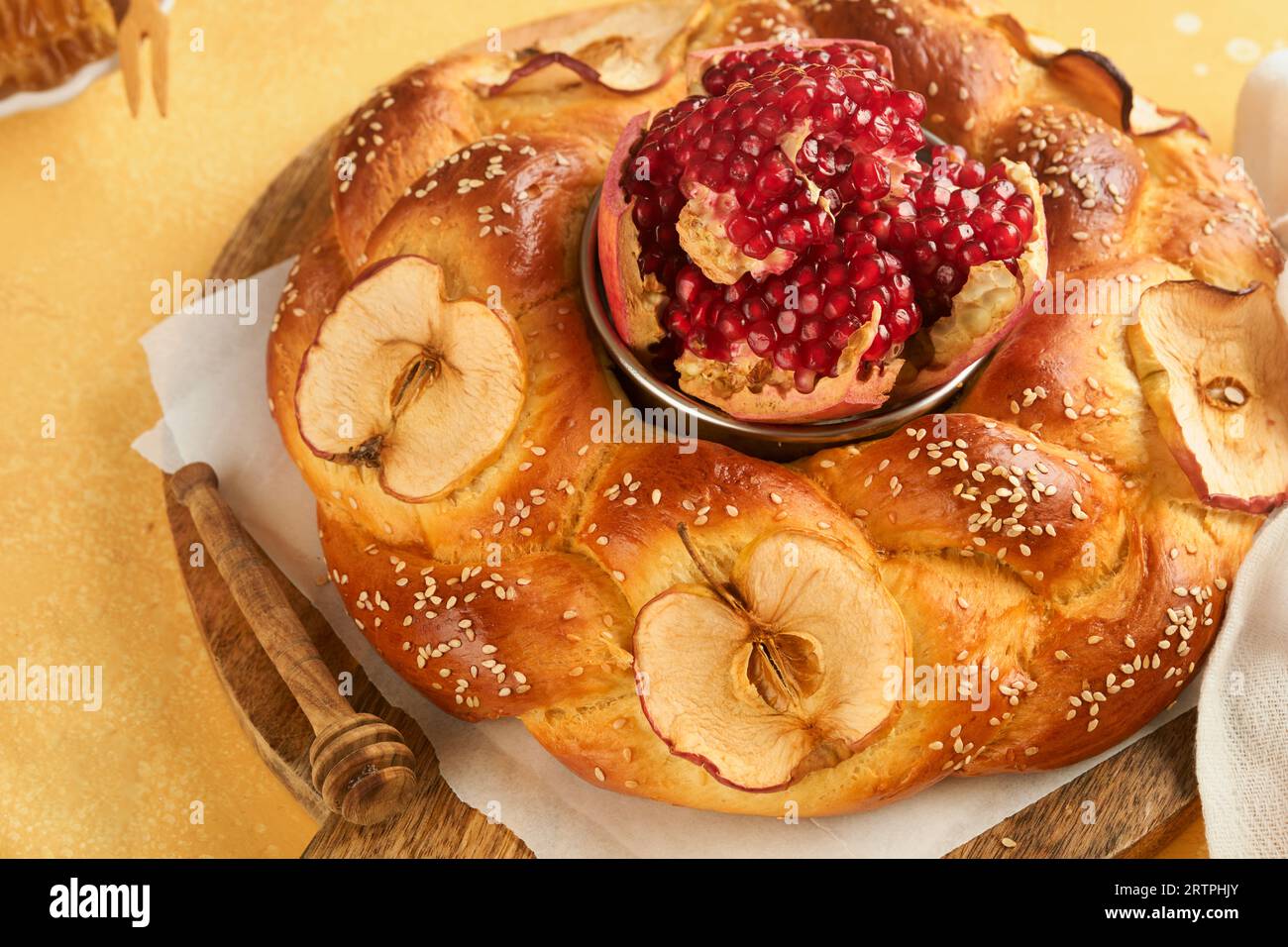 Jewish Holidays - Rosh Hashanah or Rosh Hashana. Pomegranate, apples, honey and round challah on rustic yellow table background. Jewish Autumn celebra Stock Photo