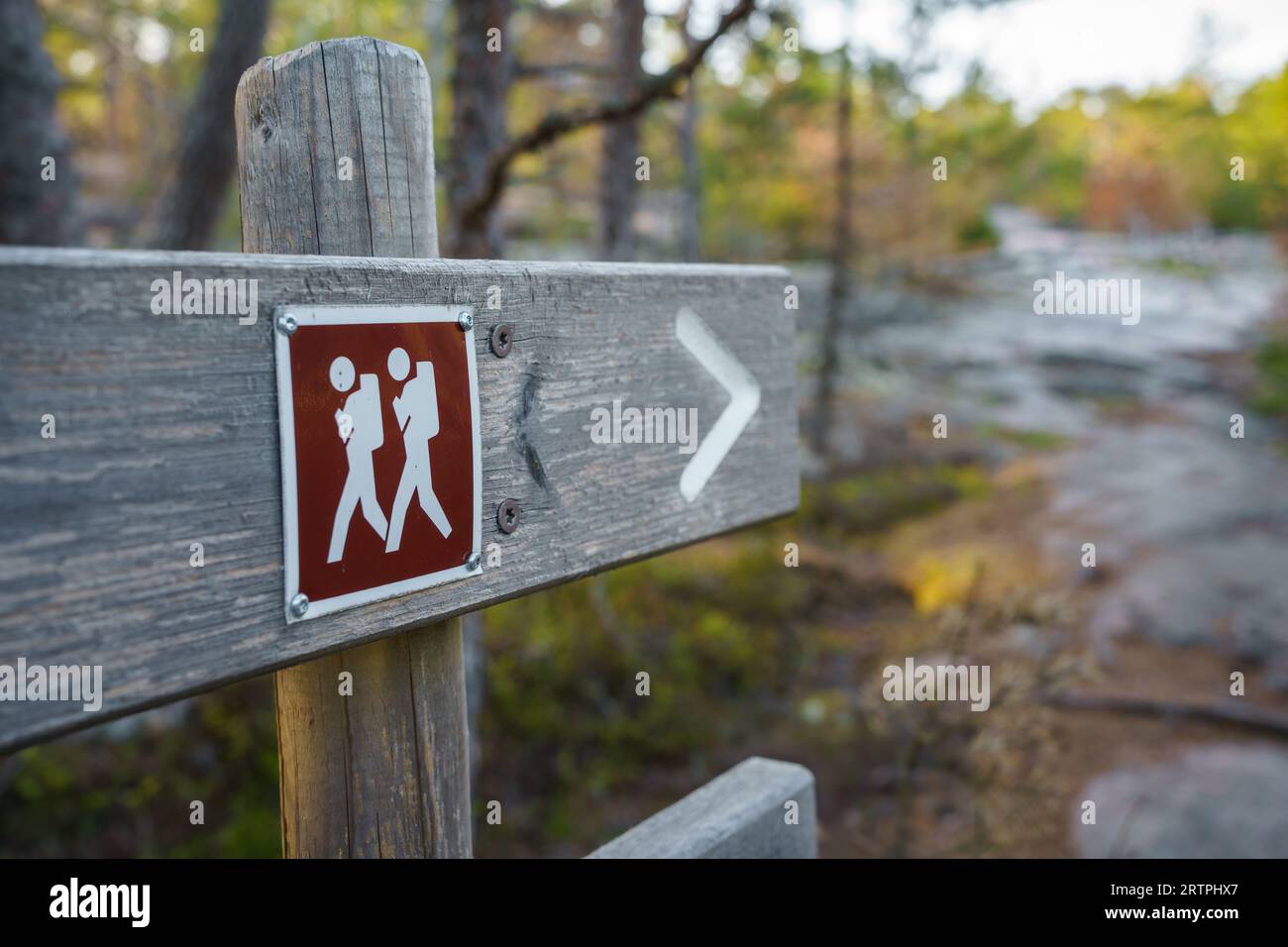 Hiking trail marker close up on a wooden signpost Stock Photo