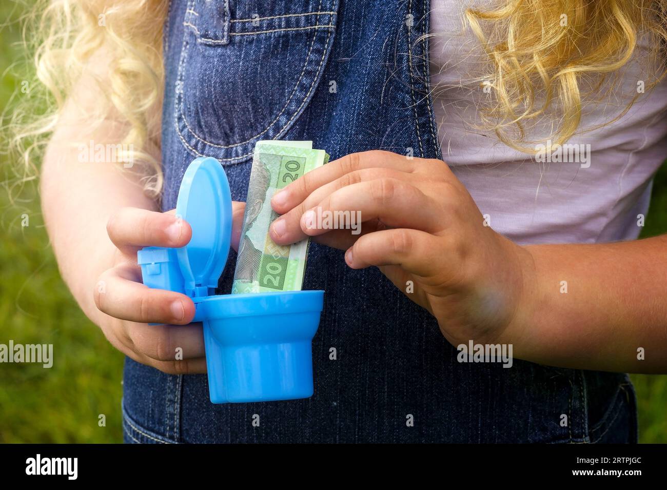 Hands holding a gold coin. Money in the toilet. concept Wasting money