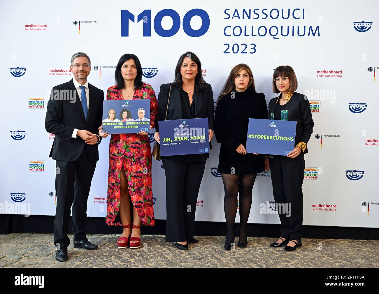 Potsdam, Germany. 14th Sep, 2023. Mike Schubert (l-r, SPD), Mayor of Potsdam, Jasmin Tabatabai, German-Iranian actress and musician, Düzen Tekkal, human rights activist, Shima Babaei, Iranian women's rights activist, and Mersedeh Shahinkar, Iranian activist hold signs reading #stopexecutions' and '#freenahid #freenarges #freejamshid' before the start of the M100 Media Awards ceremony. The M100 Media Award has been presented at the M100 Sanssouci Colloquium international media conference since 2005. Credit: Soeren Stache/dpa/Alamy Live News Stock Photo