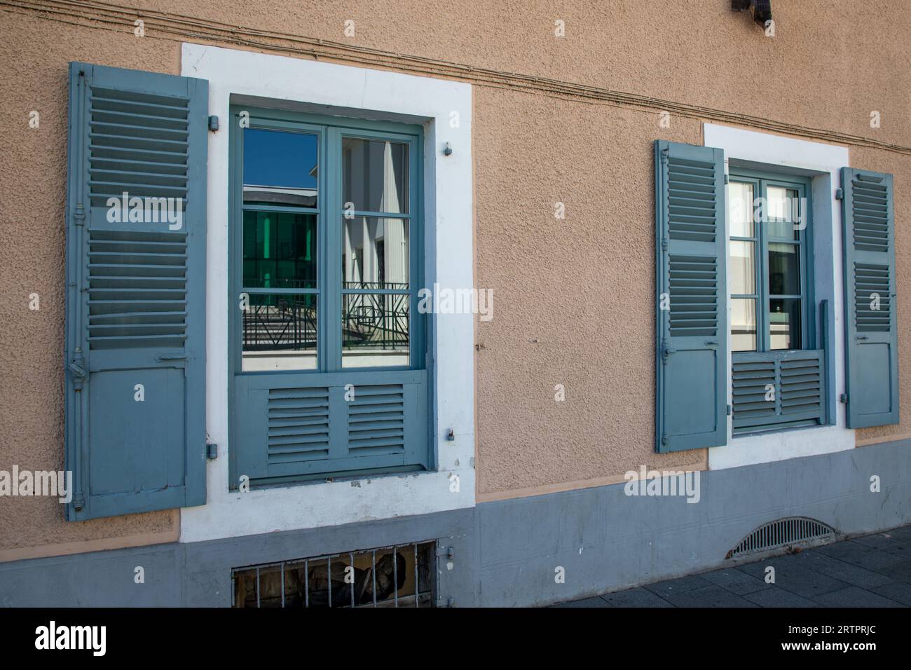 Wooden window with open shutter brown house facade with blue wood down protect with slats Stock Photo