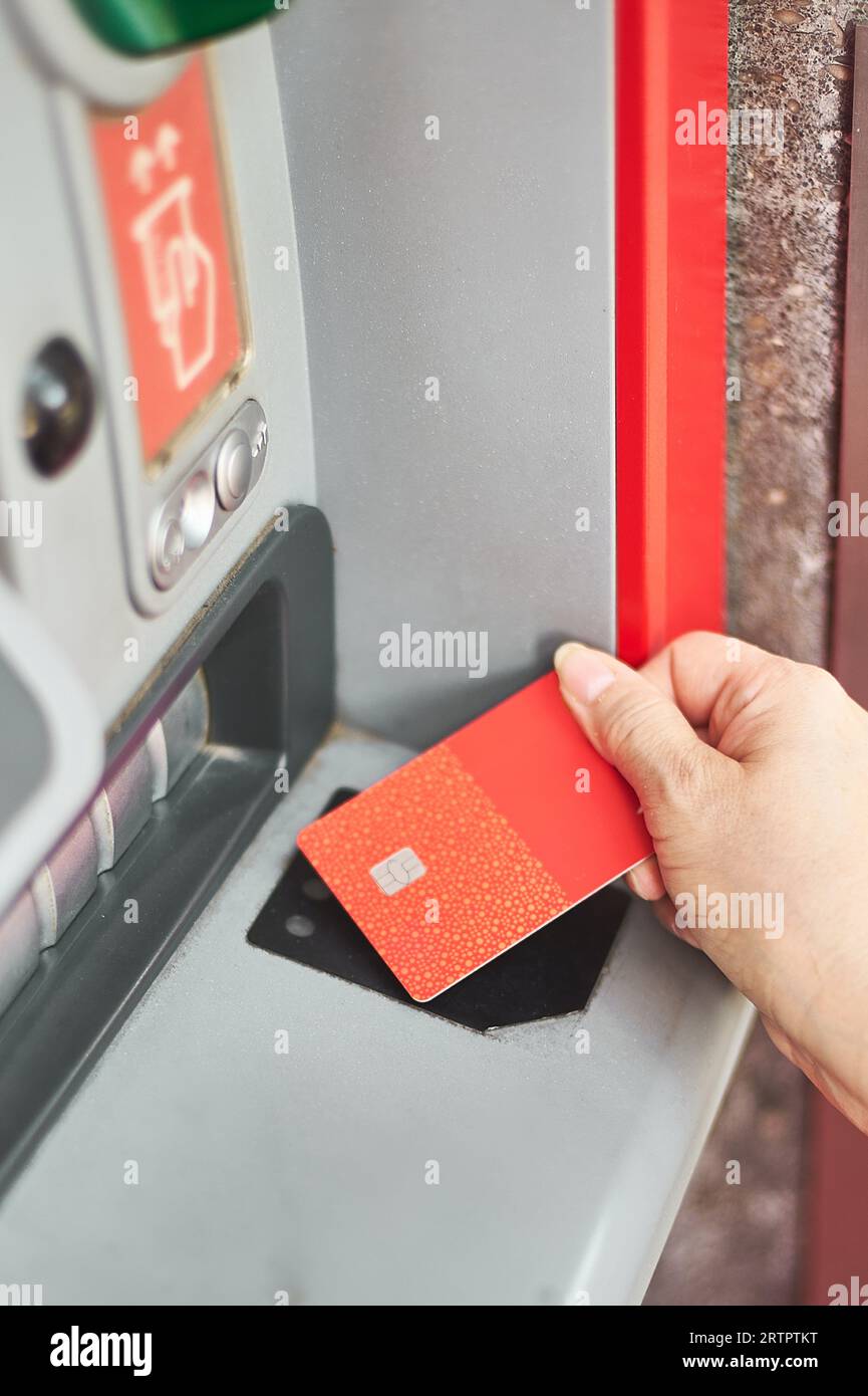 Unrecognizable woman's hand using your credit card at an ATM in selective focus. Stock Photo