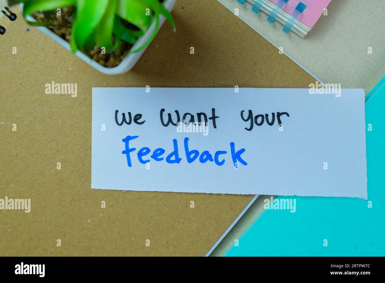 Concept of We Want Your Feedback write on sticky notes isolated on Wooden Table. Stock Photo