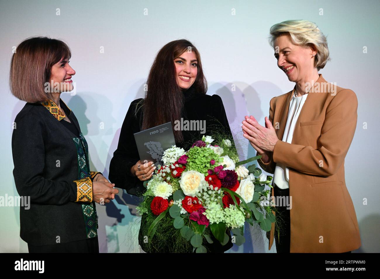 Potsdam, Germany. 14th Sep, 2023. Mersedeh Shahinkar (l), Iranian activist, and Shima Babaei (m), Iranian women's rights activist, are happy about the award after receiving the M100 Media Award next to Ursula von der Leyen (r), President of the European Commission. The Iranians accept the award on behalf of the Iranian 'Women, Life, Freedom' movement. The M100 Media Award has been presented since 2005 as part of the international media conference M100 Sanssouci Colloquium. Credit: Soeren Stache/dpa/Alamy Live News Stock Photo
