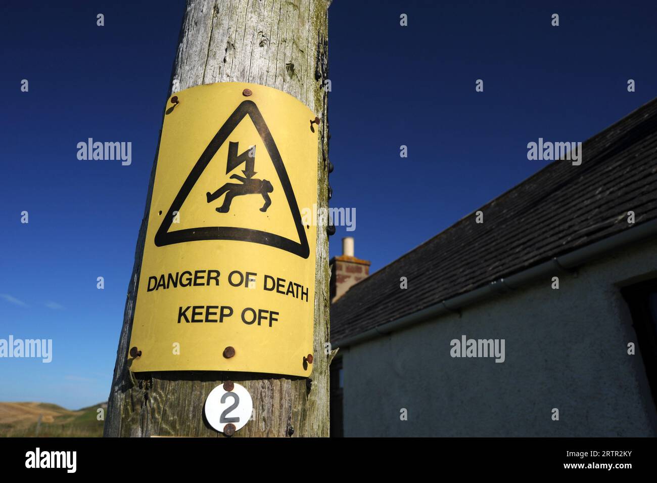 WOODEN ELECTRICITY POST WITH 'DANGER OF DEATH' SIGN RE DANGERS WARNING SIGNS ETC UK Stock Photo