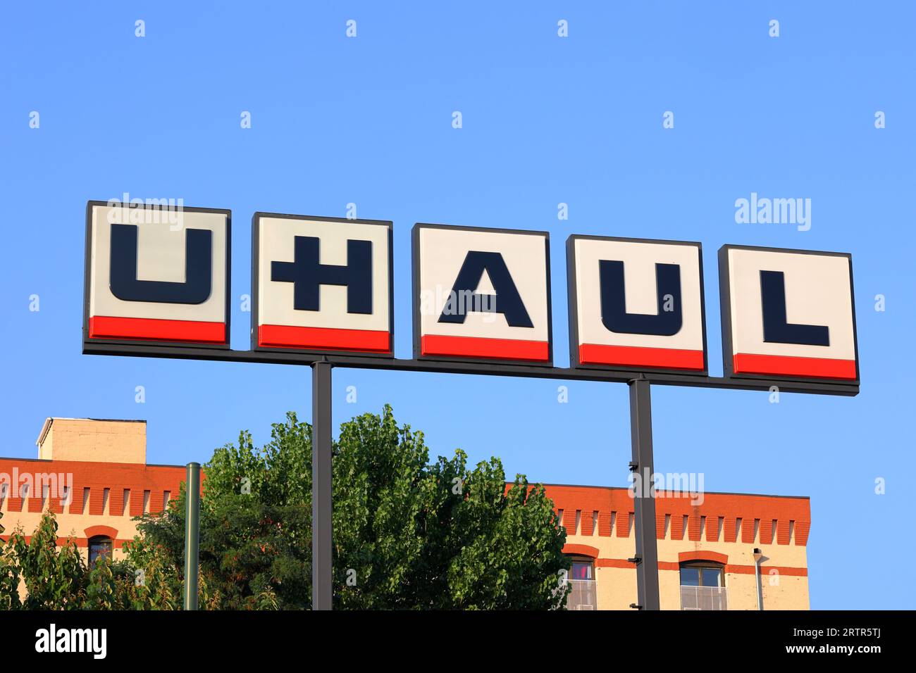 Pole signage for U Haul against a sunny blue sky. U Haul is a rental truck and moving storage company Stock Photo