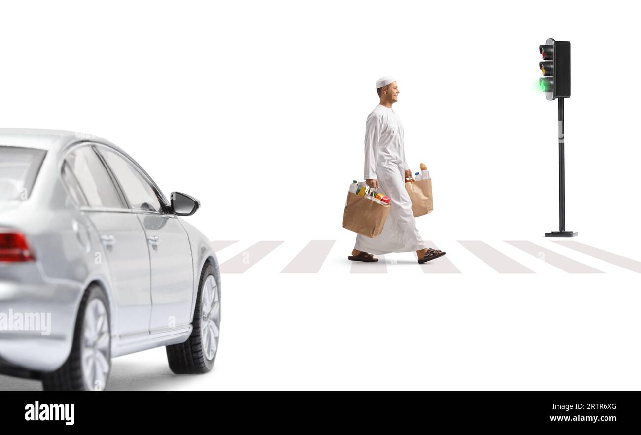Car driving and a man in ethnic clothes walking and carrying grocery