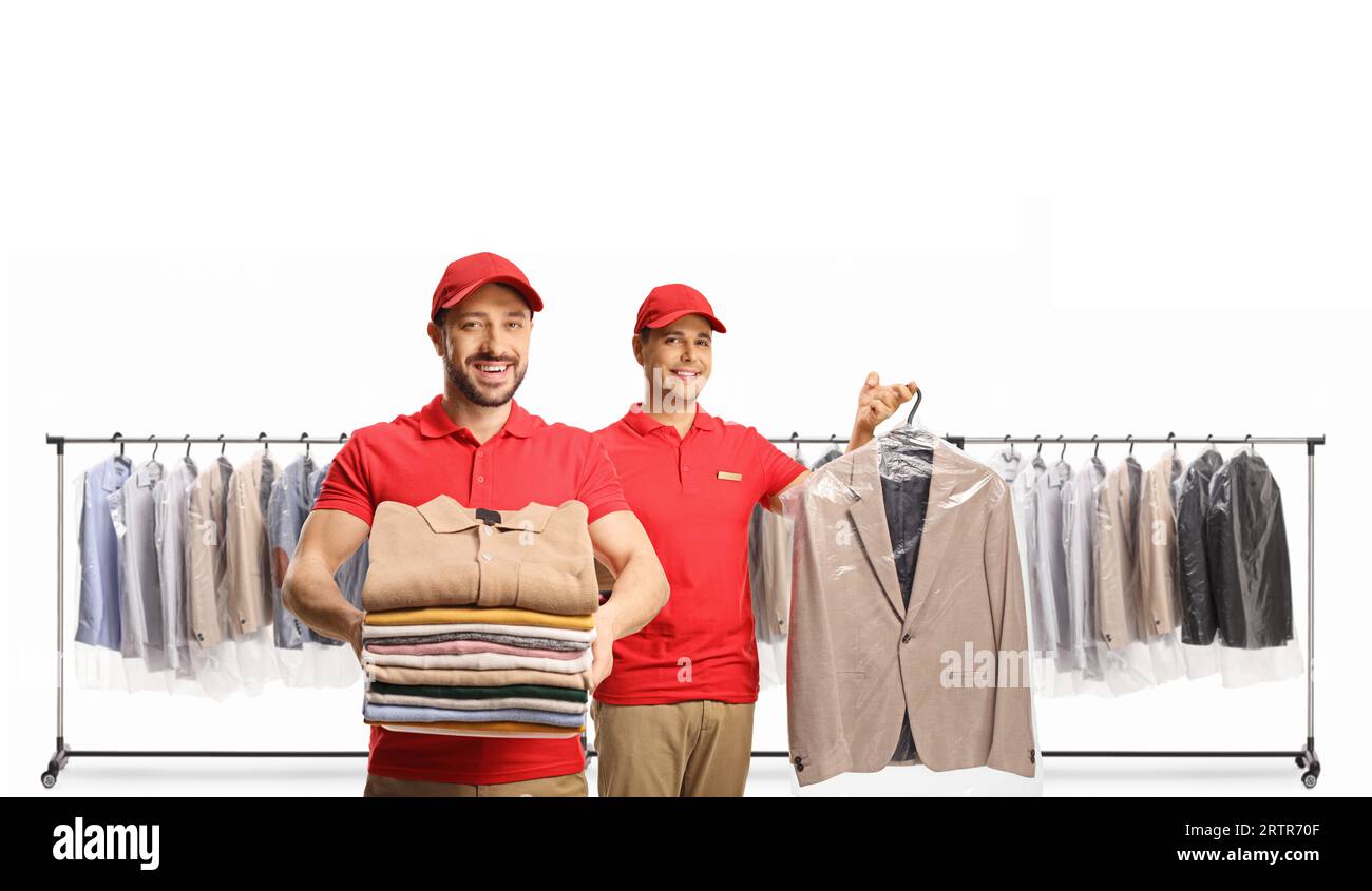 Workers holding clean clothes at the dry cleaners in front of clothing racks isolated on a white background Stock Photo