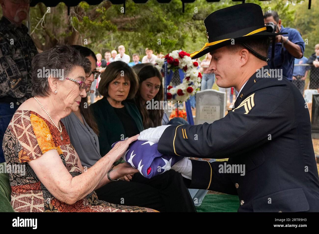Ellen Dyer, left is presented an American flag by Staff Sgt. Sayre