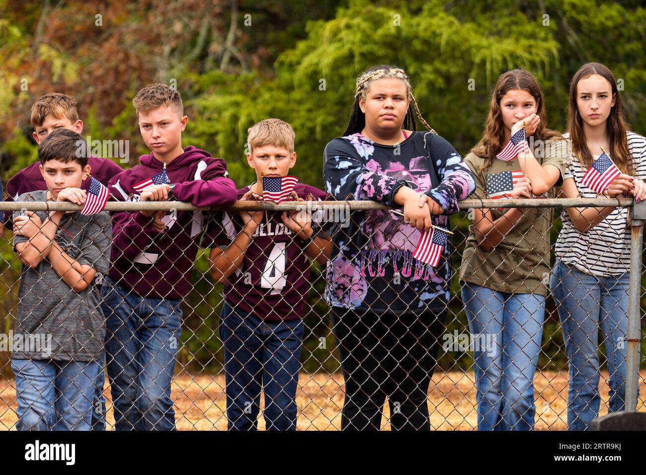 School children line a fence watching the graveside service for U.S