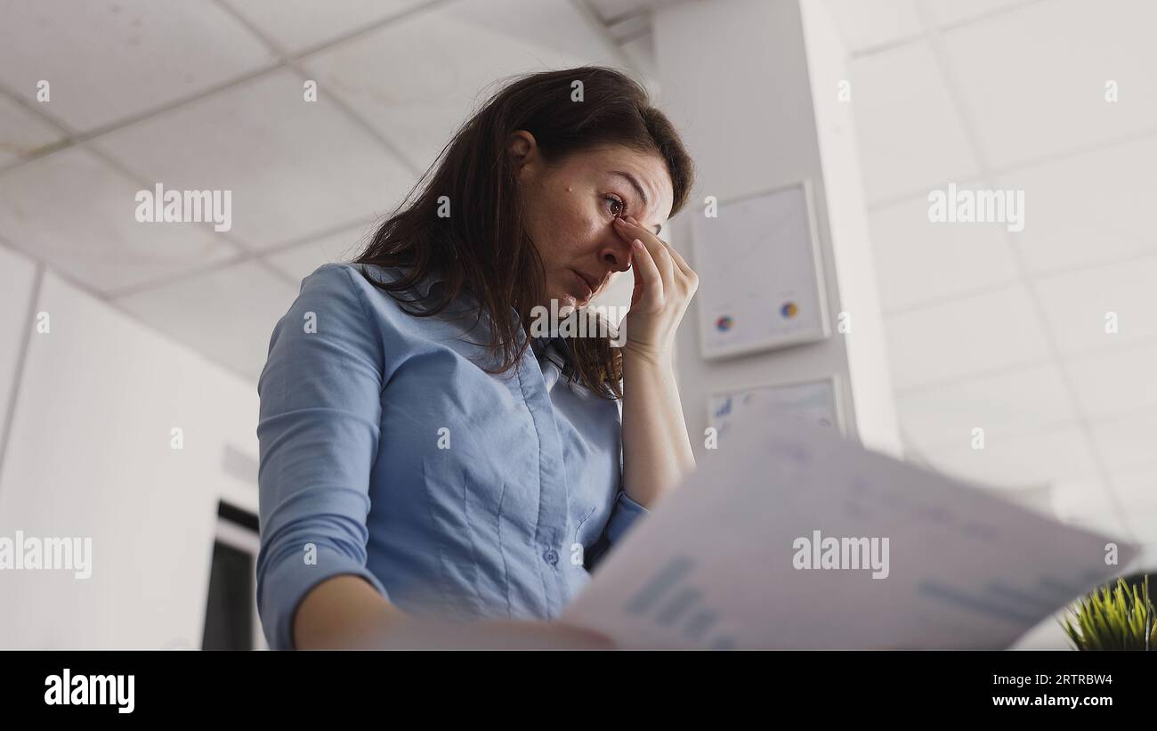 Young entrepreneur suffering from headache in office trying to work on ...