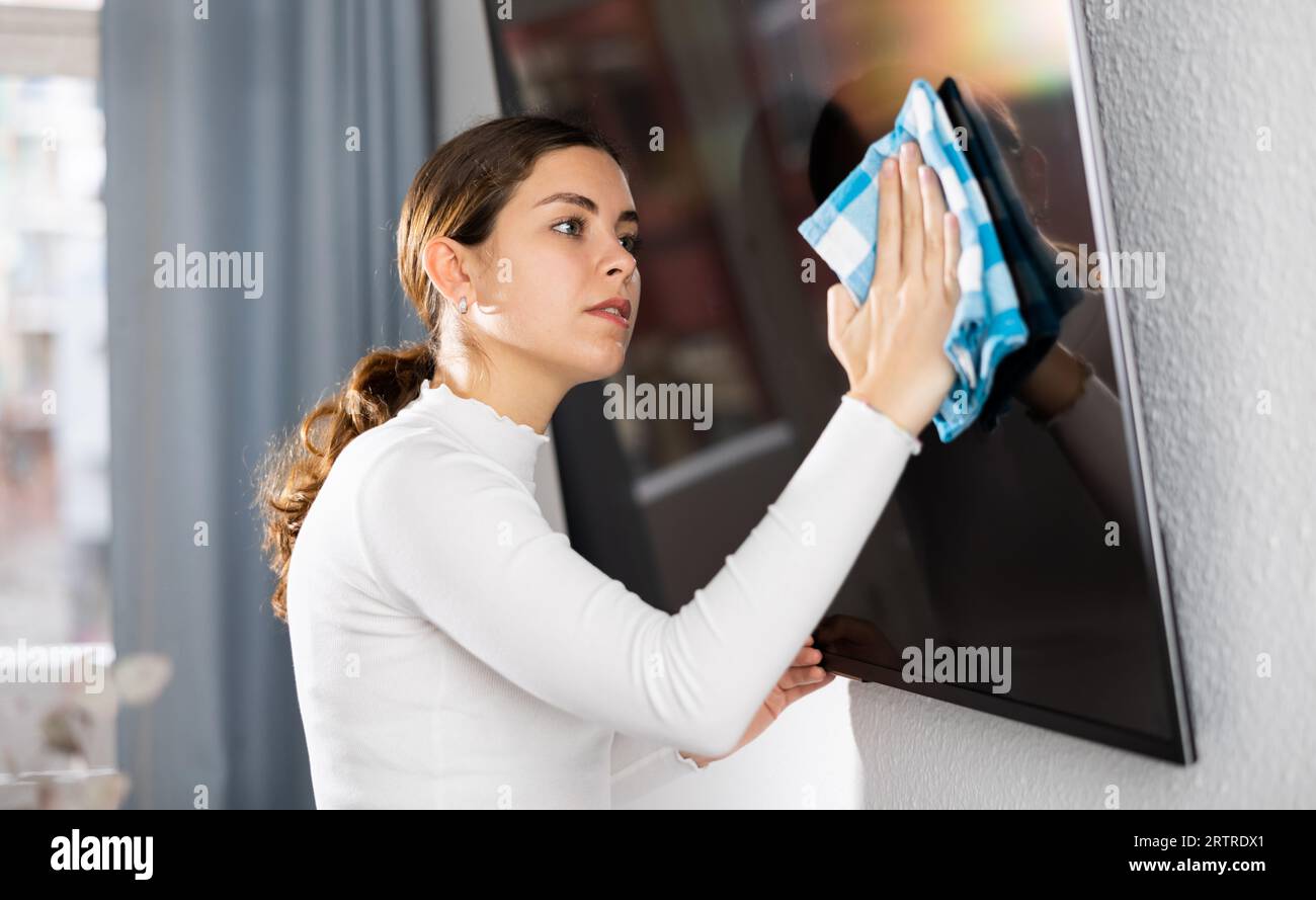 Tv Commercial Rag Young woman householder using rag to wash TV display Stock Photo - Alamy