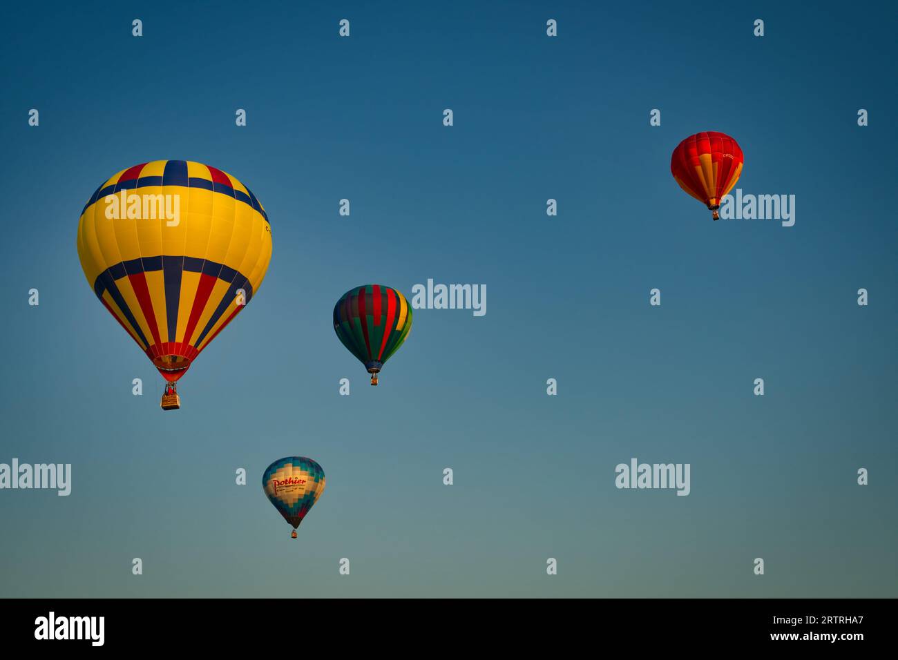 Four hot air balloons floating away into the blue sky Stock Photo