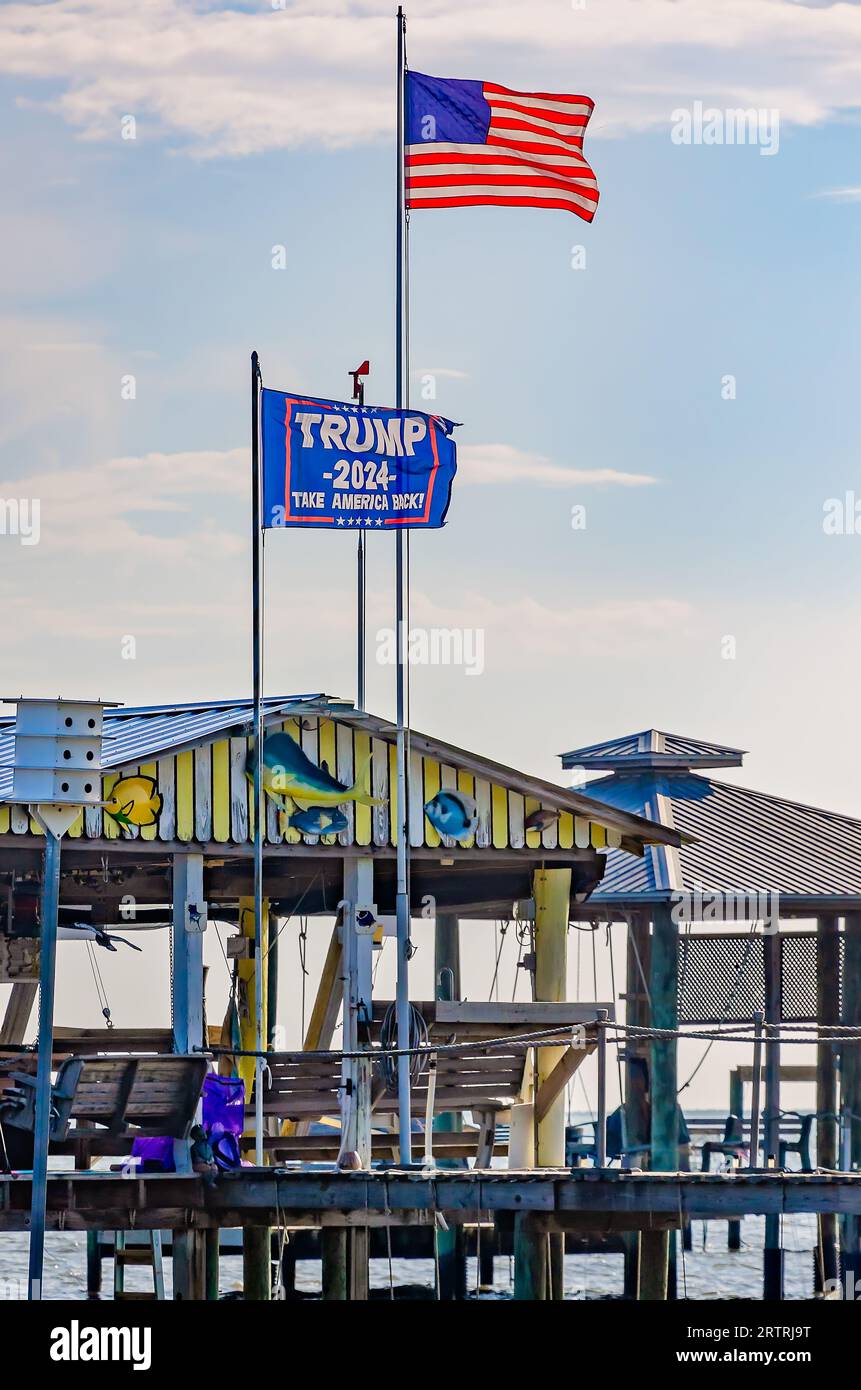 A Trump 2024 flag flies alongside an American flag at a pier on Coden