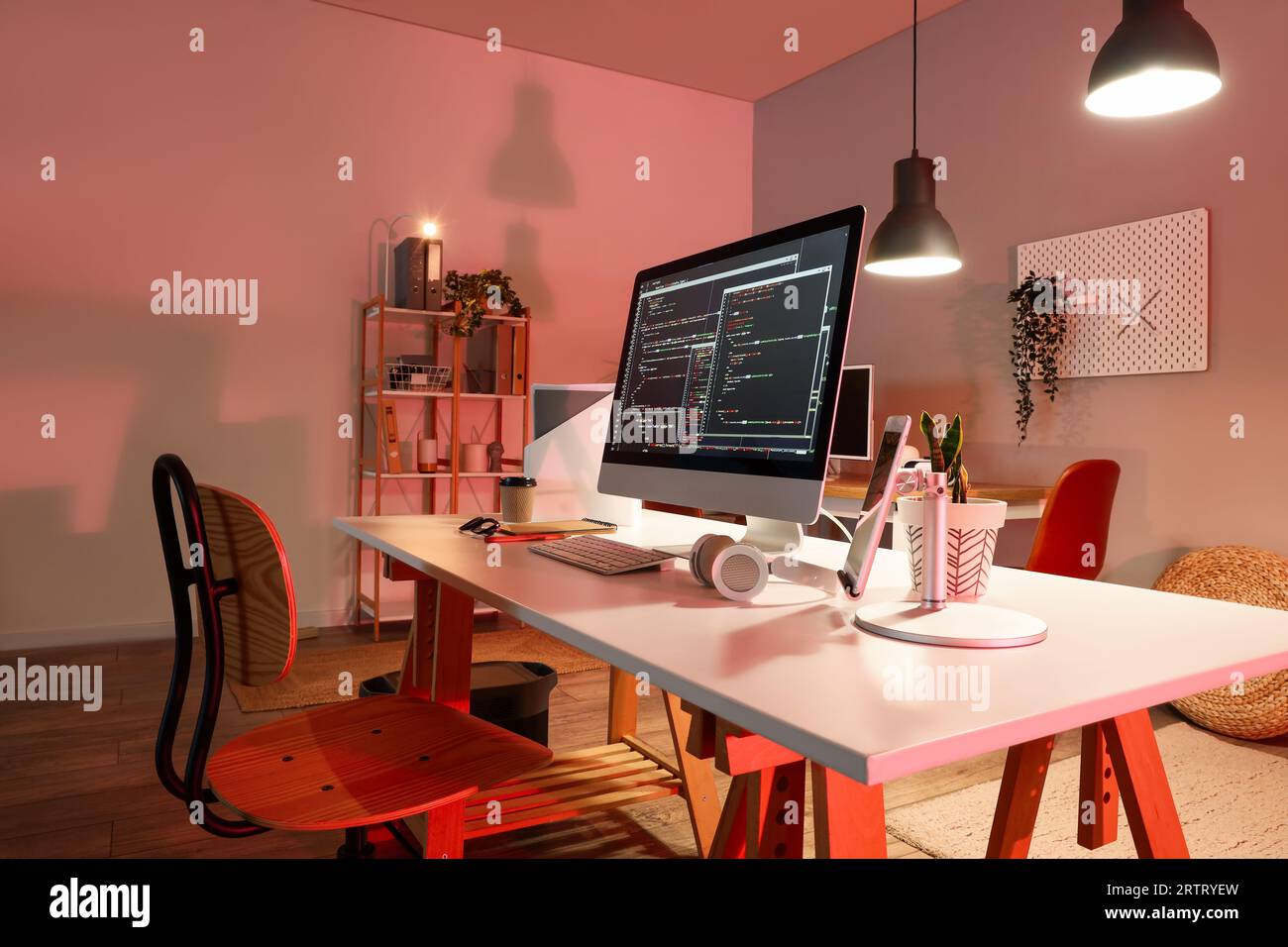 Programmer's workplace with devices in interior of dark office Stock ...