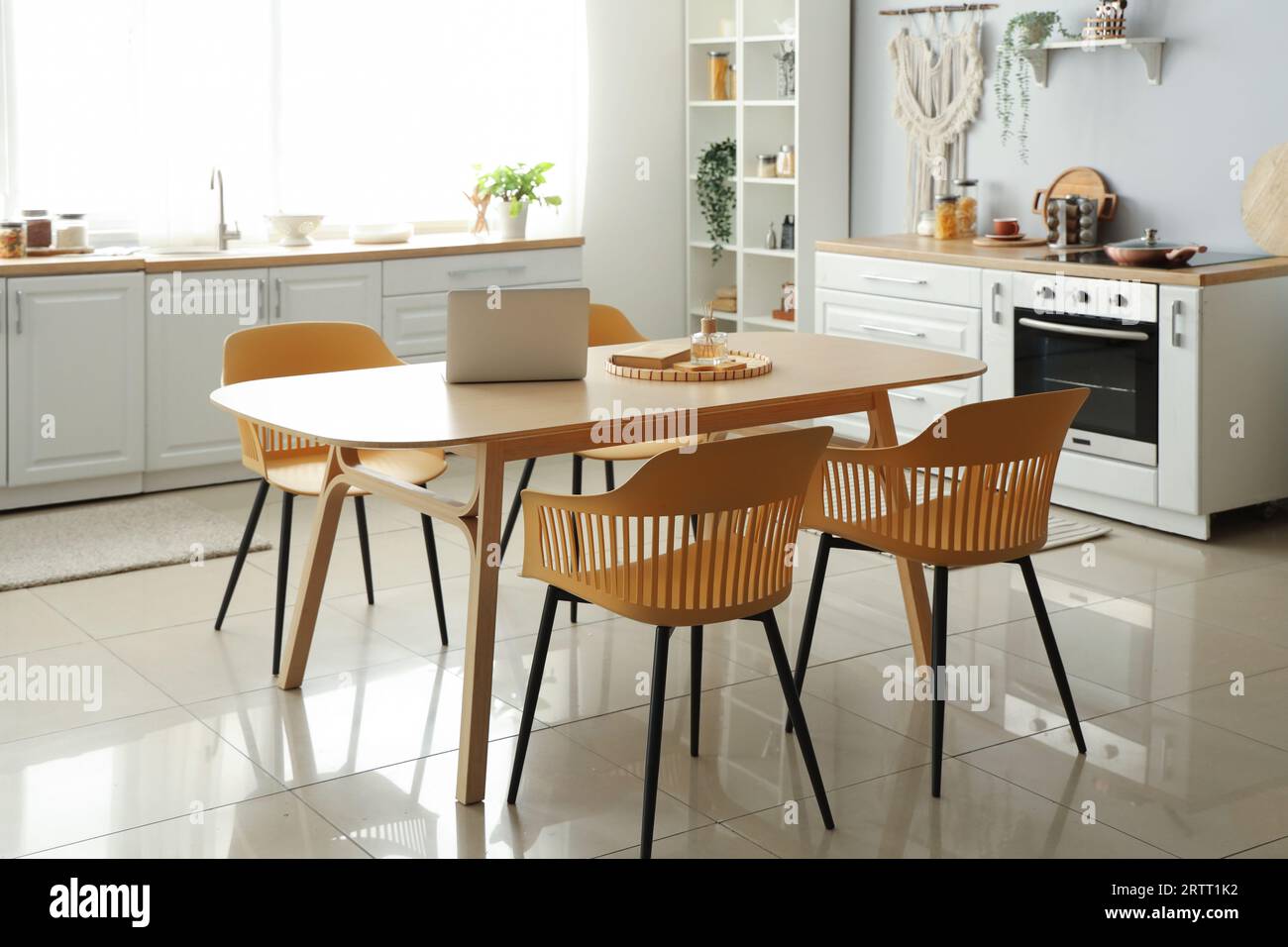 Interior of light kitchen with white counters and dining table Stock ...