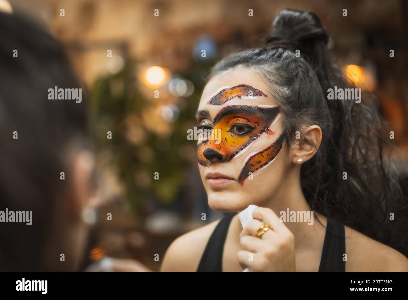 Halloween party hairstyle and makeup preparations, woman with beautiful makeup looking in the mirror Stock Photo