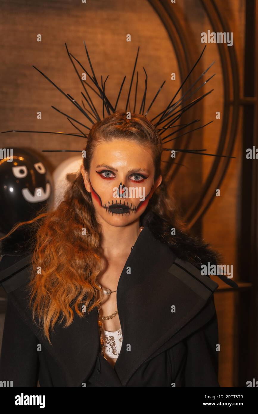 Halloween party with friends in a disco nightclub, portrait of a woman with a painted face and spiked Stock Photo