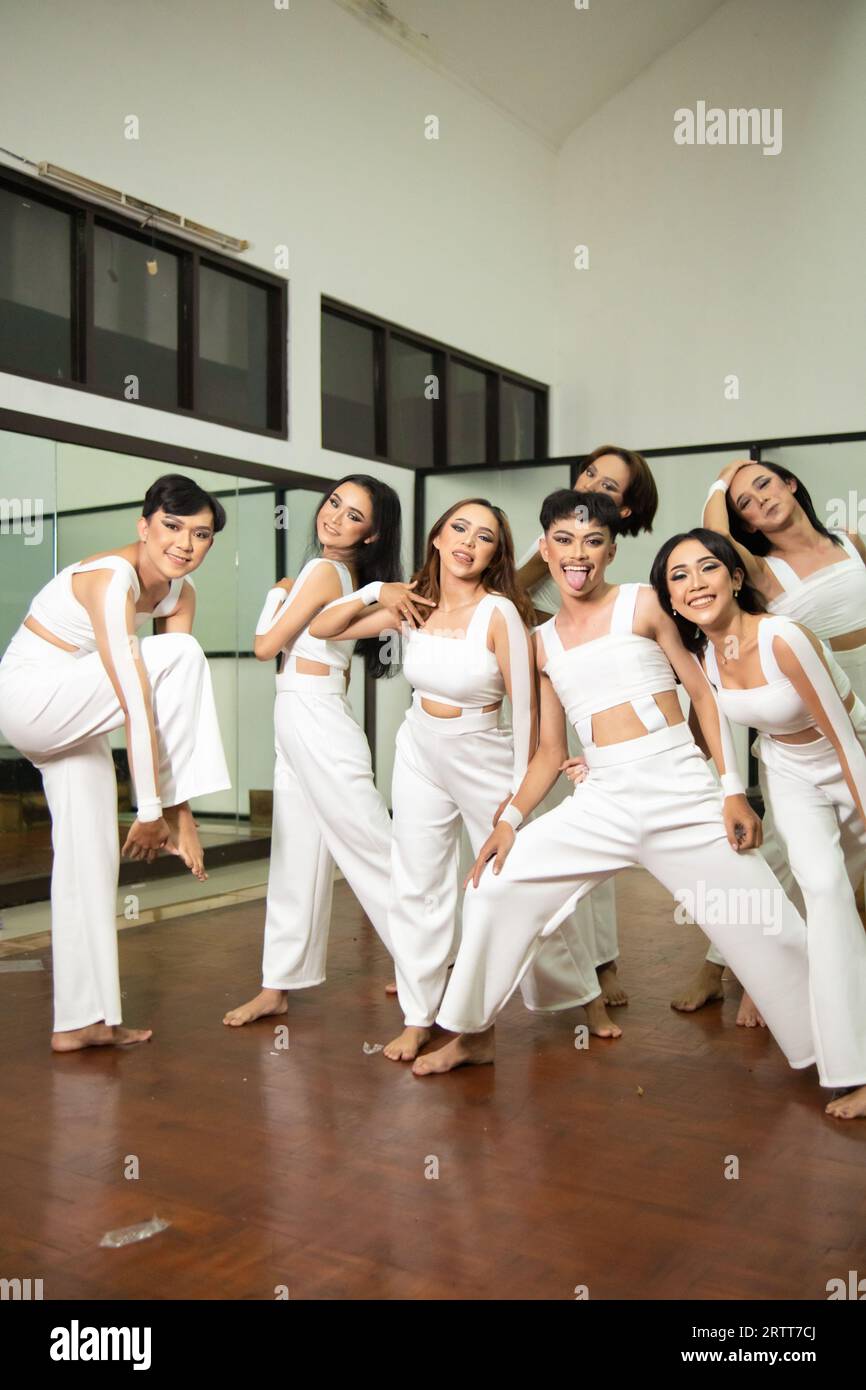 a group of Asian dancers joking around with their friends while rehearsing in a studio at night Stock Photo