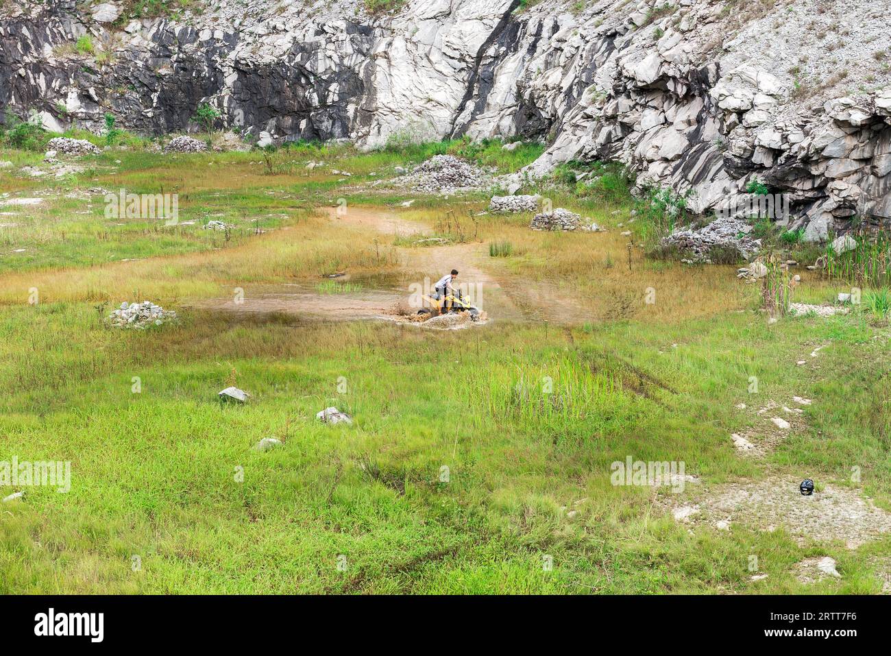 Minas Gerais, Brasil, Dec, 27, 2015: Man in nature go off road on a quad bike rally over mud puddle in countryside Stock Photo