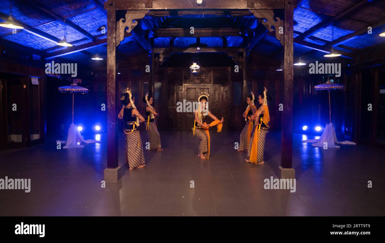 a group of sundanese dancers with jasmine and yellow shawls dance on stage at night Stock Photo