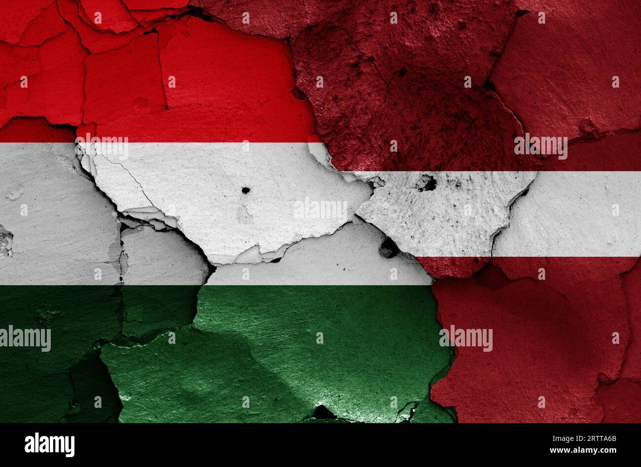 flags of Hungary and Latvia painted on cracked wall Stock Photo