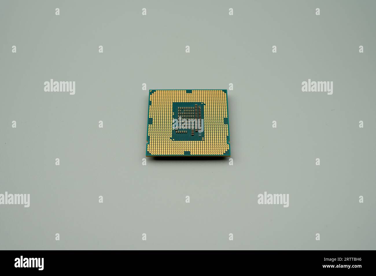 The backside of an LGA 1155 type CPU, gray background Stock Photo