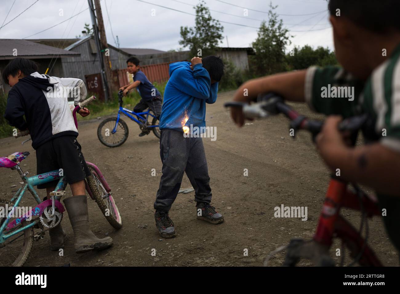 Joseph Phillip, 10, braces while igniting a firecracker with friends