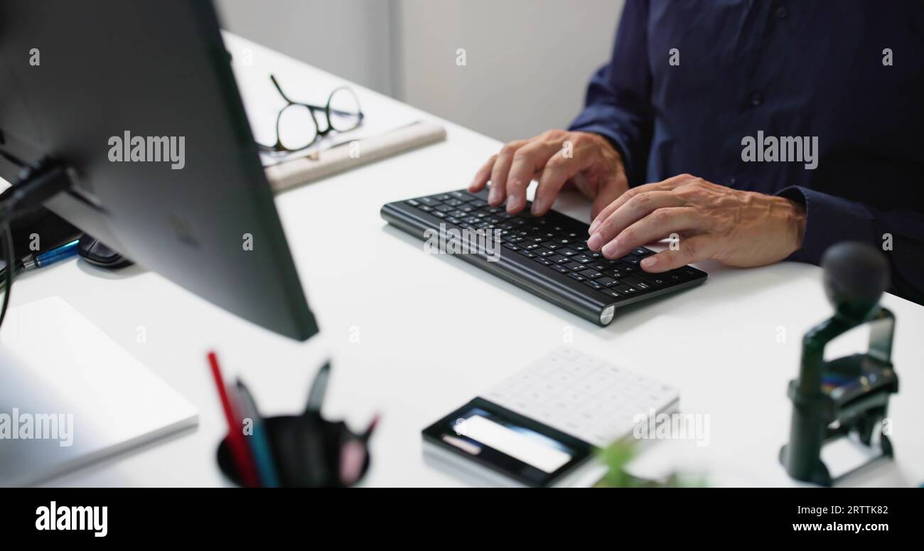 Man Working In Office On Desktop PC Stock Photo