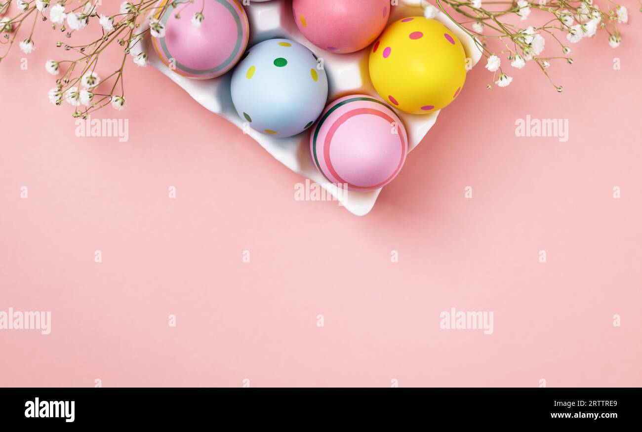 Colourful Easter eggs and gypsophila flowers background. Easter holiday composition with easter eggs with copy space. Stock Photo