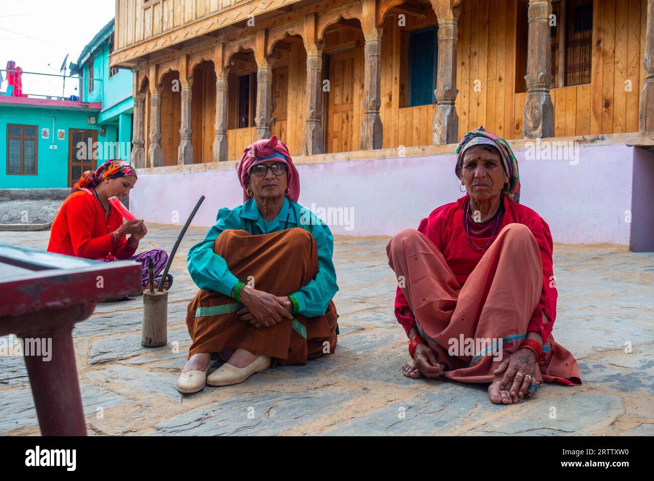 May 8th 2023, Tehri, India.Garhwali women in traditional attire gather outside a handmade Himalayan wooden home in Uttarakhand. Stock Photo